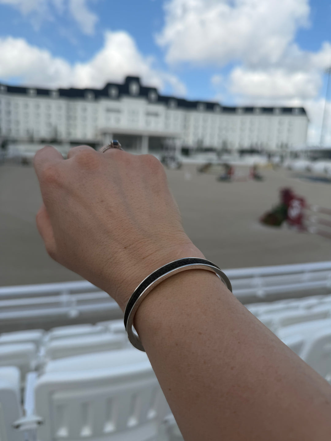 woven horsehair cuff bracelet on wrist in front of grand prix arena at world equestrian center in ocala florida
